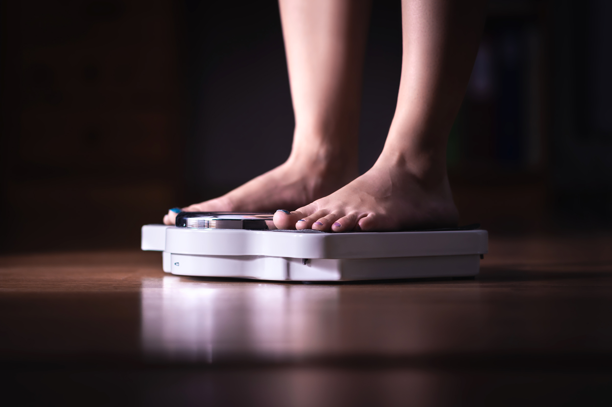 feet on scale. weight loss and diet concept. woman weighing hers