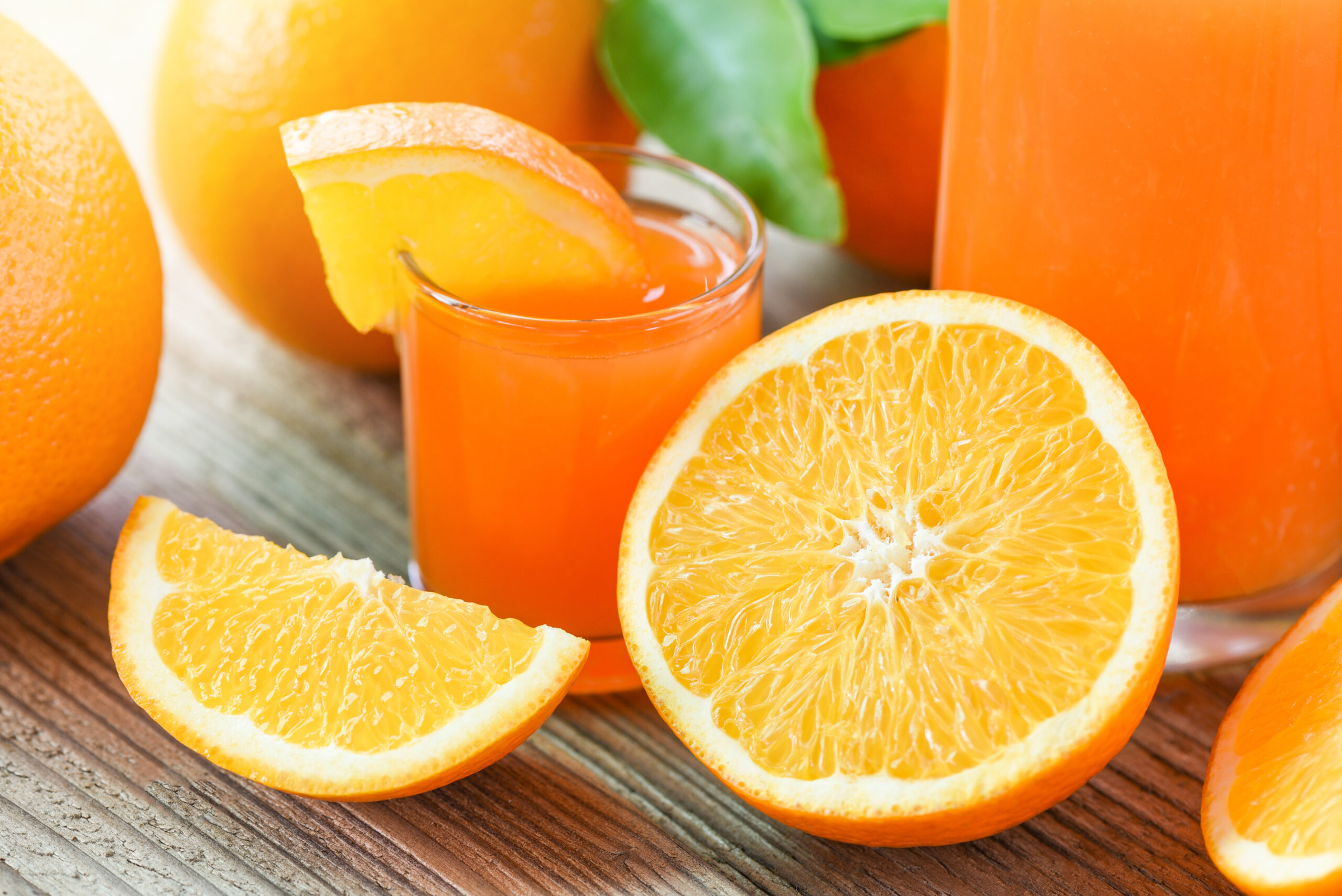 Fresh Orange Juice In The Glass With Orange Fruit On Wooden Back