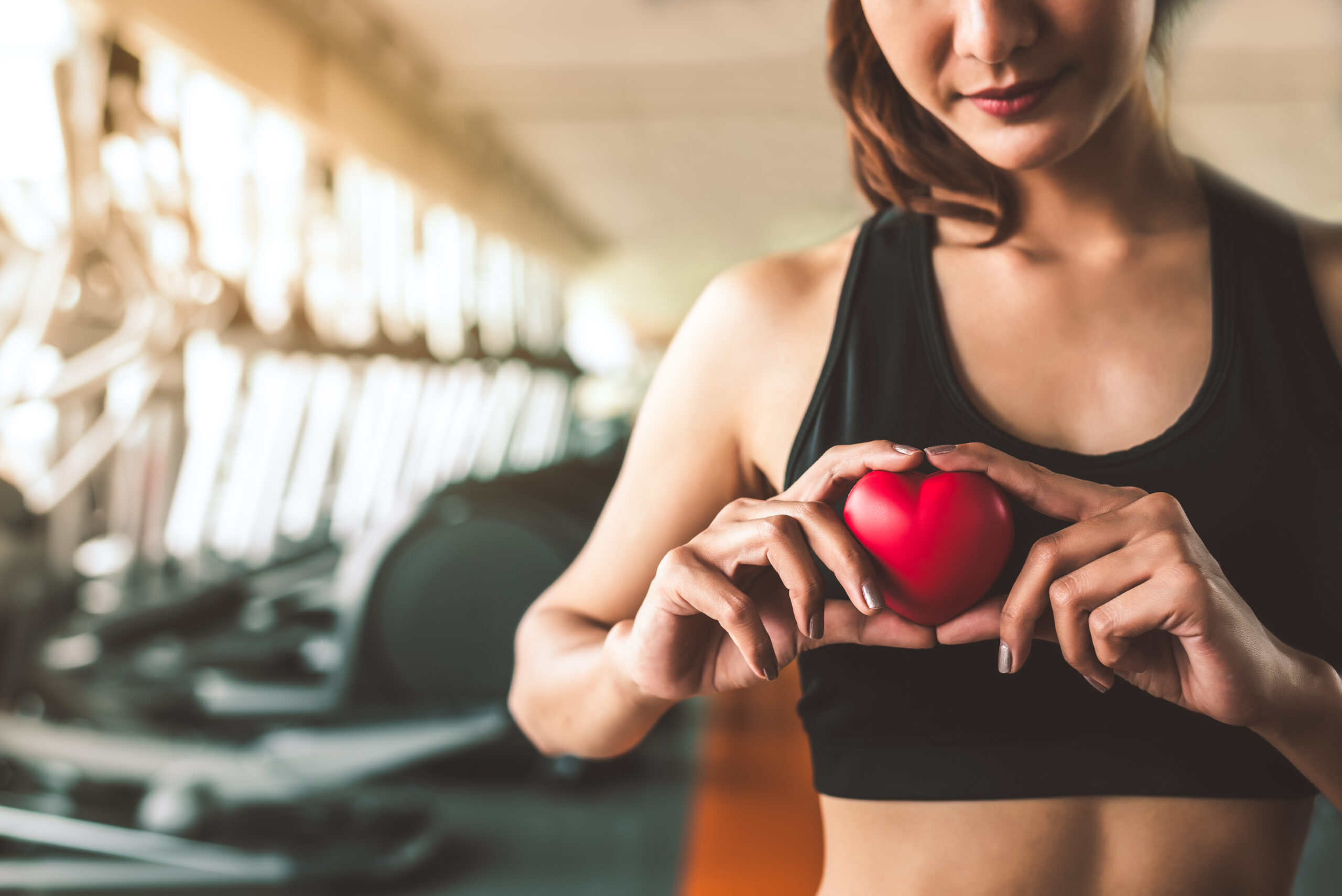 happy sport woman holding red heart in fitness gym club. medical
