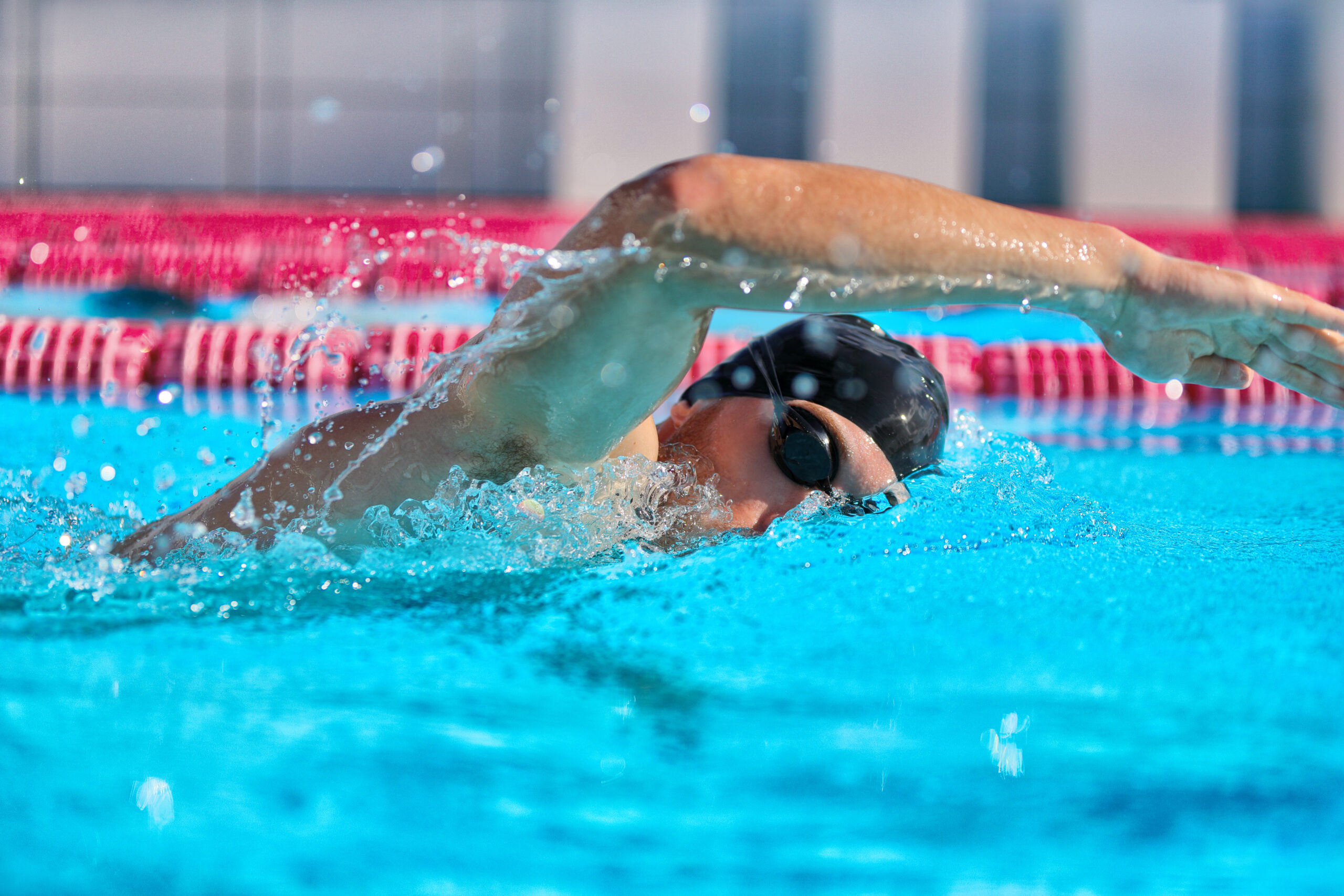 swimmer man doing crawl swim in swimming pool portrait. closeup